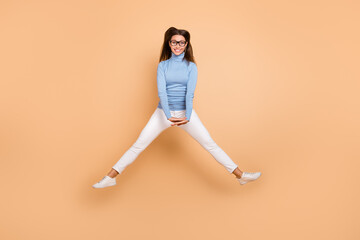 Fototapeta na wymiar Full body photo of sweet millennial lady jump wear spectacles pullover trousers sneakers isolated on beige background