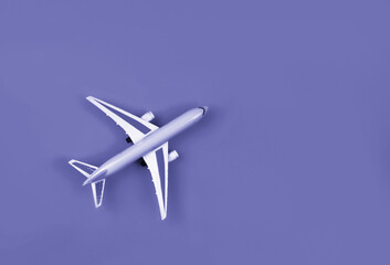 Naklejka na ściany i meble Airplane, miniature on very peri lavender background.