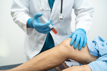Asian doctor inject Hyaluronic acid platelet rich plasma into the knee of senior woman to walk...