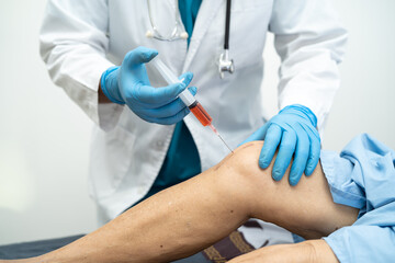 Asian doctor inject Hyaluronic acid platelet rich plasma into the knee of senior woman to walk without pain.