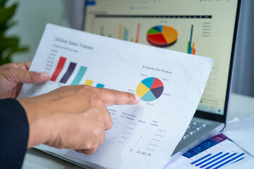 Asian accountant working and analyzing financial reports project accounting with chart graph and...
