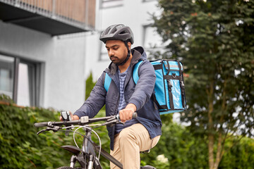 food shipping, profession and people concept - delivery man with thermal insulated bag, smartphone and bicycle on city street