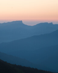 Mountain silhouette layers in the sunset light. Beautiful photography of the nature, blue layered background. Natural gradient.