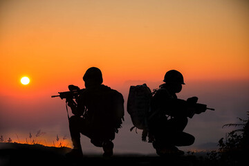 Soldiers in uniform patrolling outdoors.