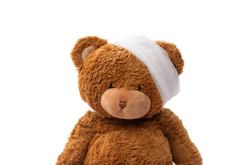 medicine, healthcare and childhood concept - teddy bear toy with bandaged head on white background