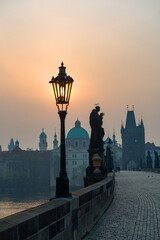 Obraz premium Sunrise over the capital of the Czech Republic - Prague city with silhouettes of buildings and statues