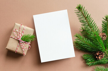Christmas greeting card mockup with gift box and fir tree branches with cones