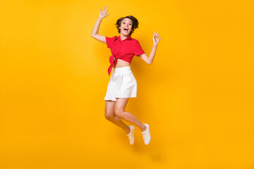 Fototapeta na wymiar Full size photo of impressed nice brunette lady jump wear shirt skirt isolated on yellow color background