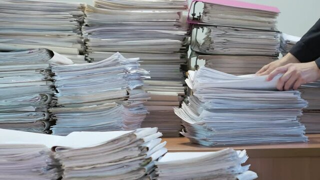 Stack of blank papers with binder clips on wooden table indoors. Workplace. Many documents, contracts, legal agreements, papers on work table. Concept of business, working, job