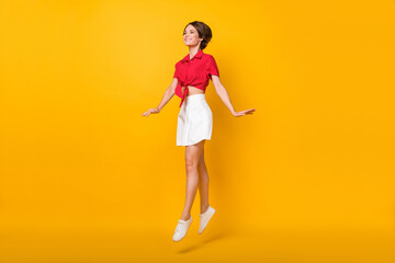 Fototapeta na wymiar Full size photo of optimistic nice brunette lady jump wear shirt skirt isolated on yellow color background