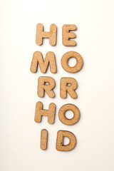 Concept of hemorrhoids with wooden letters on white background