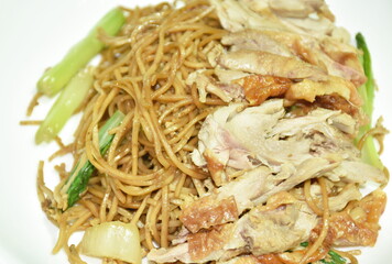 stir fried Chinese yellow noodles topping slice boiled duck in black sweet soy soy sauce on plate