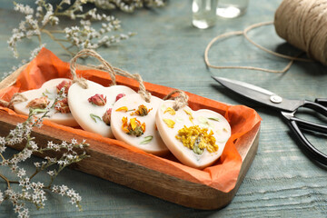 Tray with scented sachets on blue wooden table