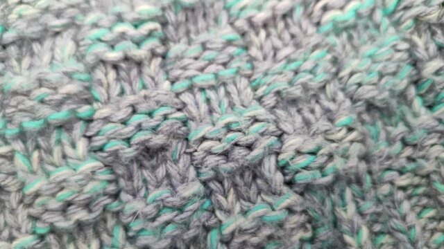 Knitted wool background made of melange yarn. The real texture of the knitted fabric. Different types of knitting. Soft wool macro shooting. Rotation, close-up.