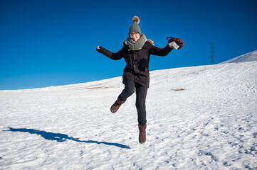 Una mujer salta feliz en un paisaje nevado