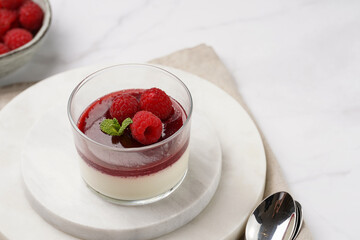 Italian dairy dessert panna cotta with raspberry jam and fresh raspberries on marble board
