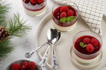 Italian dairy dessert panna cotta with raspberry jam and fresh raspberries on concrete tray