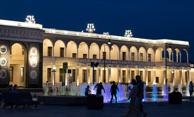 people look at the colorful fountain at night