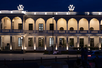 manor house glowing with lights at night