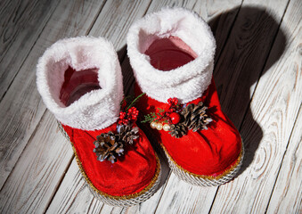 Red santa claus boots on a white wooden background. Handmade, new year 2022. Close-up
