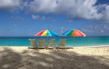 Beach chairs and colorful umbrellas on Paradise beach in Nassau, Bahamas