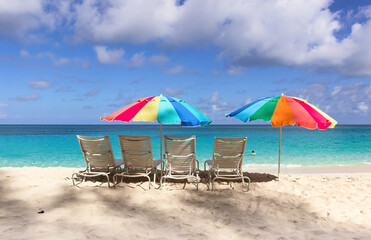 Beach chairs and colorful umbrella on Paradise beach in Nassau, Bahamas