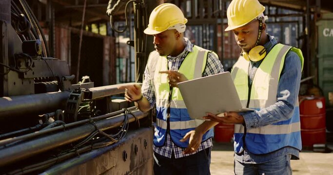 Team Engineer African American technician are using laptop to inspect machine equipment in construction site with professional. Checking  and Maintenance to be in perfect condition and ready to use. 