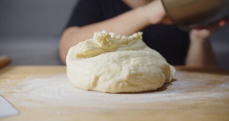 Close up fluffy dough on wooden board, preparing kneading dough bread bakery at home kitchen	

