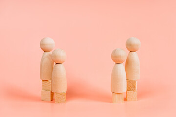 Abstract wooden toy figures people stand at different levels symbolizing social inequality and...