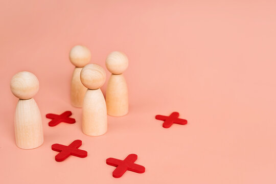 Wooden models of little men stand in a staggered order or as in the game of tic-tac-toe. The concept of choice and positions in society. Social distance