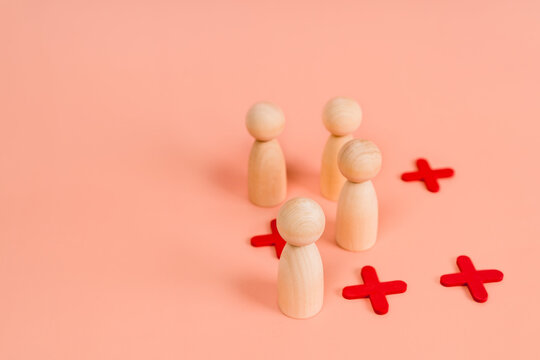 Wooden models of little men stand in a staggered order or as in the game of tic-tac-toe. The concept of choice and positions in society. Social distance