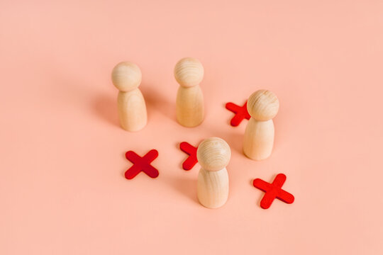 Wooden models of little men stand in a staggered order or as in the game of tic-tac-toe. The concept of choice and positions in society. Social distance