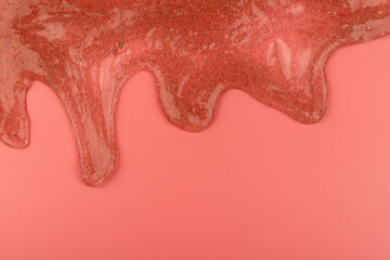 Coral transparent slime with bubbles inside on pink background. Kids toy slime.