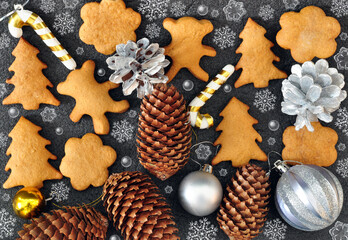 Christmas background with cookies in a shape of bears, chreestmas trees, and snowflakes, silver and golden balls, pine cones, candy cane