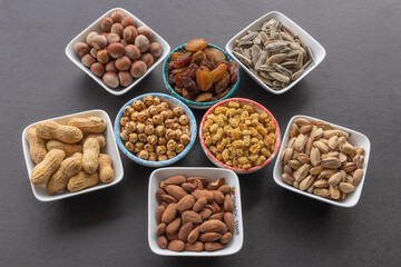 Almond in selective focus. Dried mulberry, hazelnut, pistachio, grape, pistachio, yellow chickpea and sunflower seeds in the background.