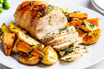 Stuffed chicken breast roll served with potato and sweet potato garnish on the festive table.