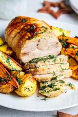 Stuffed chicken breast roll served with potato and sweet potato garnish on the festive table.