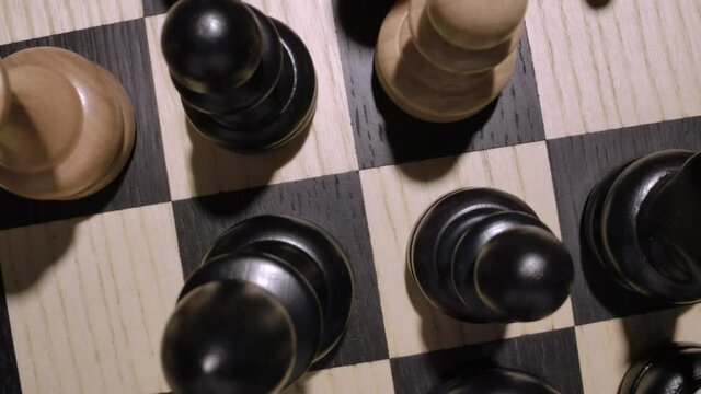 rotating chessboard with combination of white and black wooden chess figures . Top view. Camera moves from the macro to the top view. High quality 4k footage