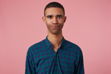 Obraz premium studio portrait of middle age middle eastern man wears blue checkered shirt looks into camera with disgust, irritated facial expression. isolated over pink background