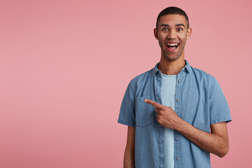 studio portrait of middle age middle eastern man wears blue shirt points aside with positive, happy...