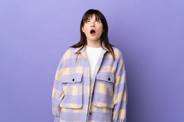 Young Ukrainian woman isolated on purple background looking up and with surprised expression