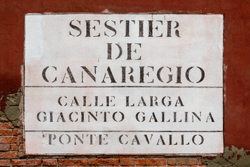 Street nameplate in Venice painted on dark red wall