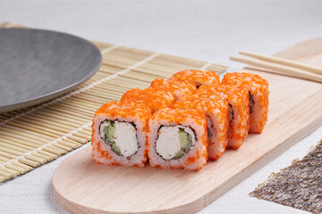 a portion of rolls on a stand, japanese food, sushi on the table, chinese chopsticks, light background