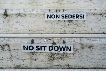 Funny translation on warning labels in Venice forbidding tourists to sit down