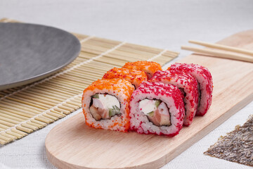 a portion of rolls on a stand, japanese food, sushi on the table, chinese chopsticks, light background
