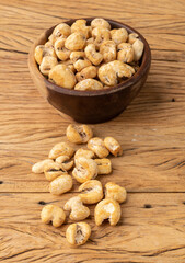 Canjica, hominy or white corn popcorn, sweet popcorn in a bowl over wooden table