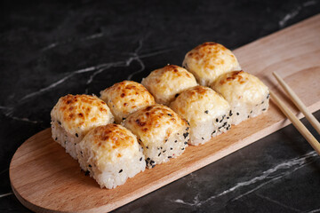 a portion of rolls on a stand, japanese food, sushi on the table, chinese chopsticks, dark background