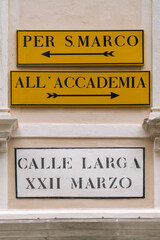 Direction signs in Venice with arrows pointing to San Marco