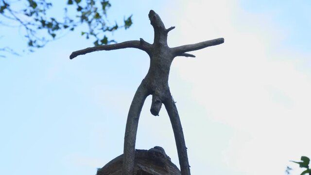 Silhouette wooden snag in the form of a pagan idol against the cloudy sky