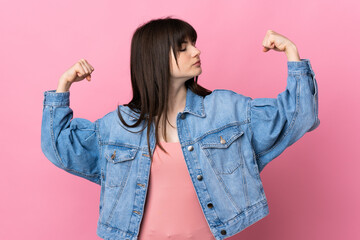 Young Ukrainian woman isolated on pink background doing strong gesture